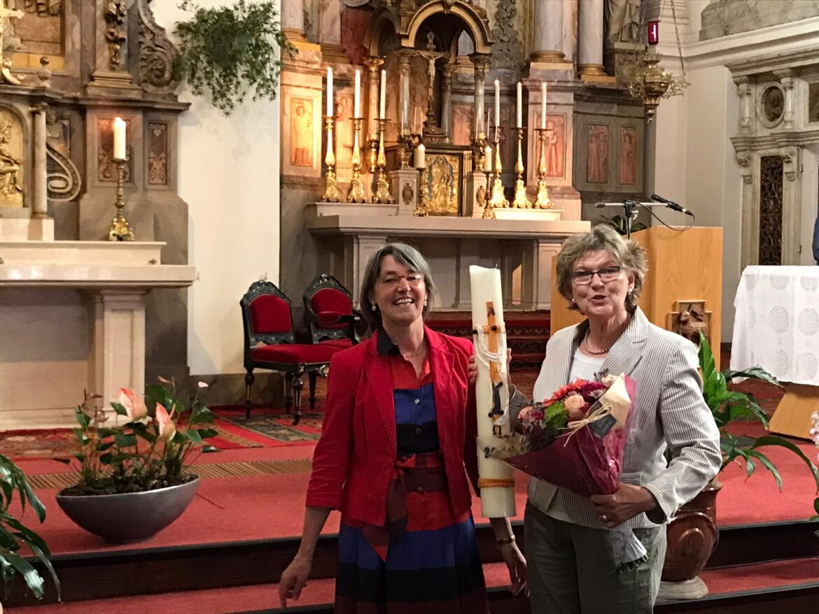 Uit handen van Alison McDonnell Wilma van der Stelt de paaskaars van afgelopen jaar mee.